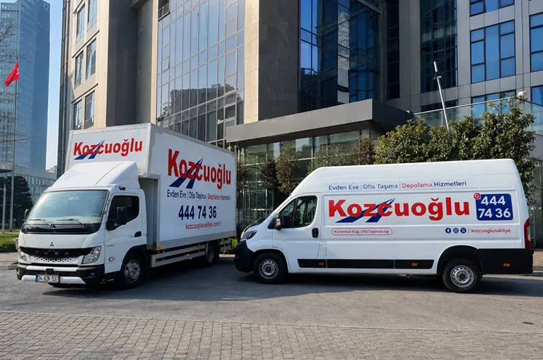 Bağcılar ofis taşıma hizmeti için İstanbul’da modern ofis binası önünde park eden Kozcuoğlu nakliye araçları
